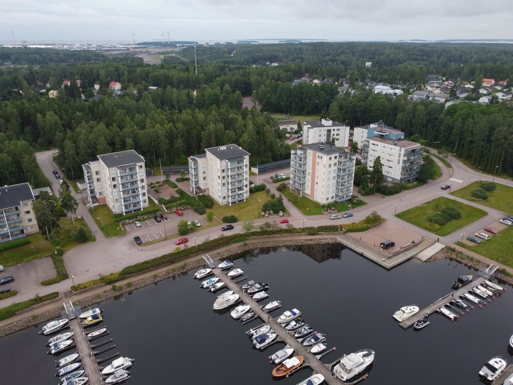 Ilmakuva Kotkan Hirssaaresta. Pienvenesatama-alue, jonka vieressä kerrostaloasuntoja.