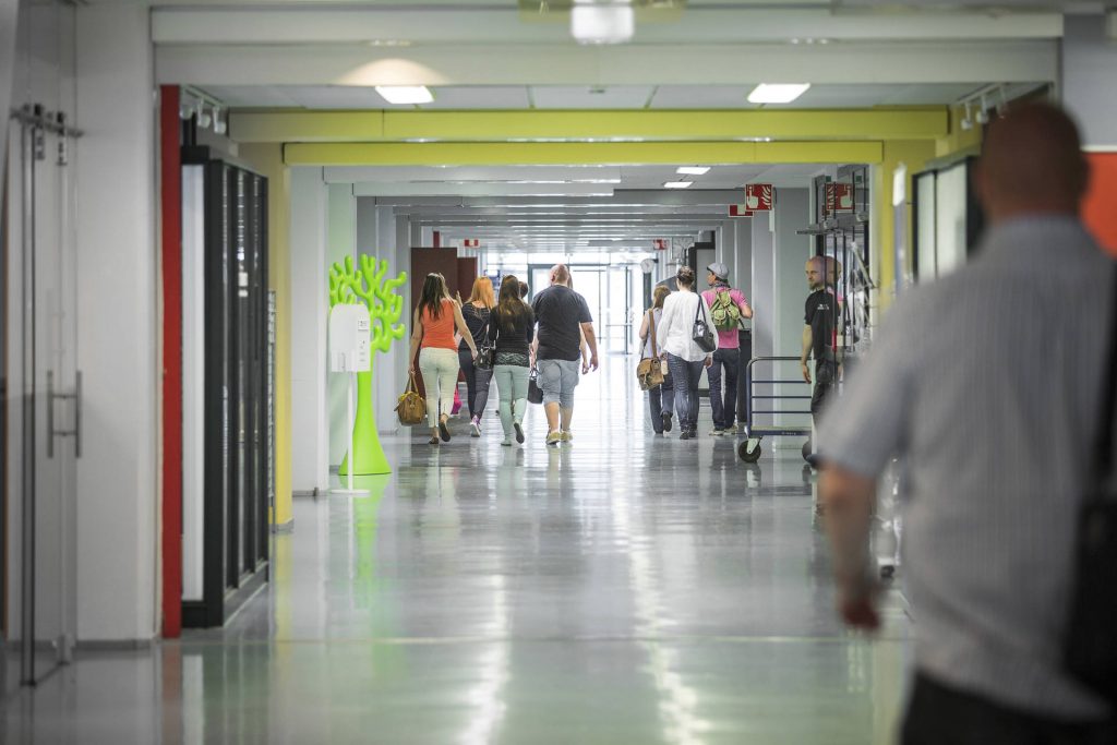 Pitkä käytävä, jossa kävelee ihmisiä.